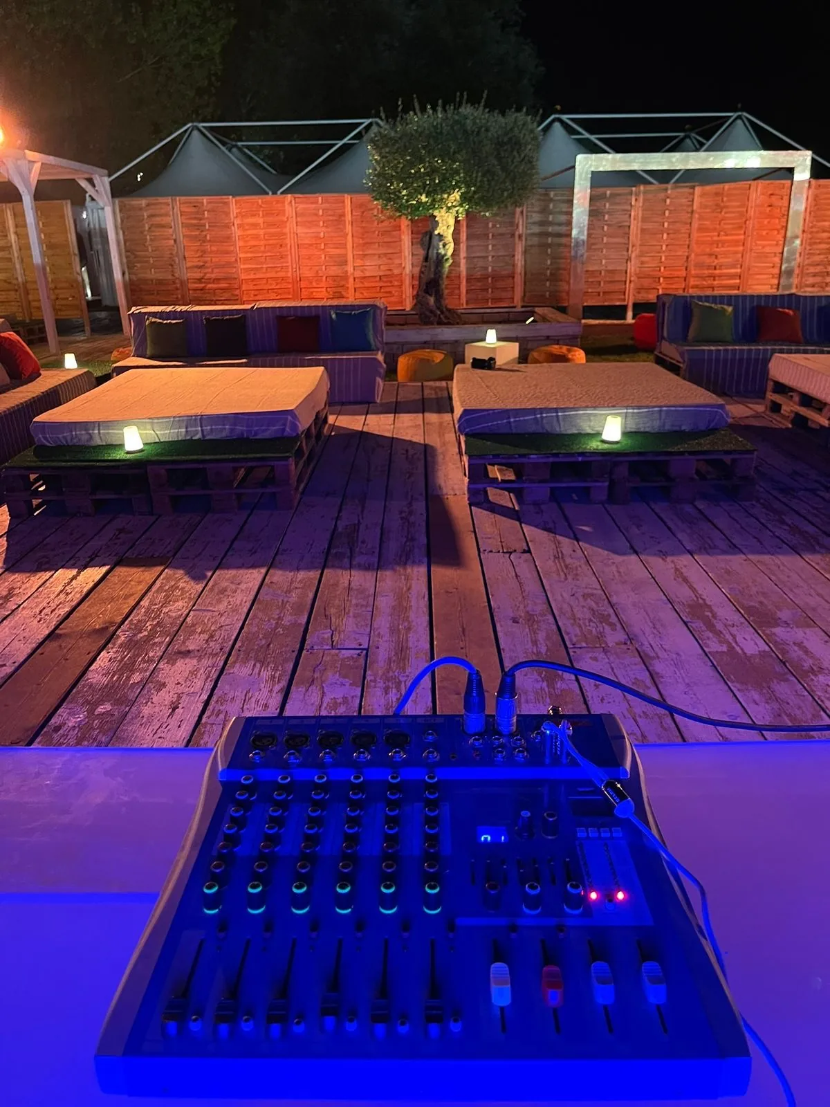 Il deck lounge con l'ulivo illuminato di sera